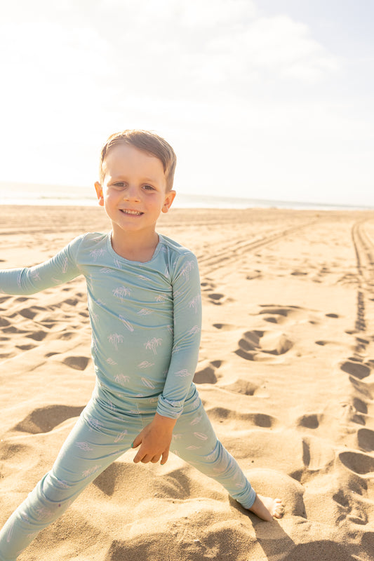 Surfside Dreams big kids bamboo pajama set by Shae & Palmer featuring surfboards, palm trees, and ocean-inspired details in soft seafoam hues.