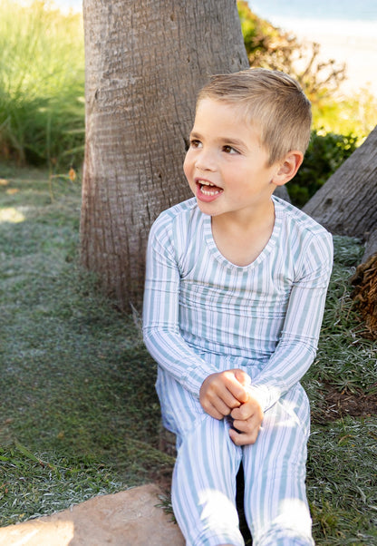 Toddler wearing Shae & Palmer Studio Stripe Green Haze bamboo pajamas featuring modern muted green stripes and buttery-soft breathable bamboo fabric.