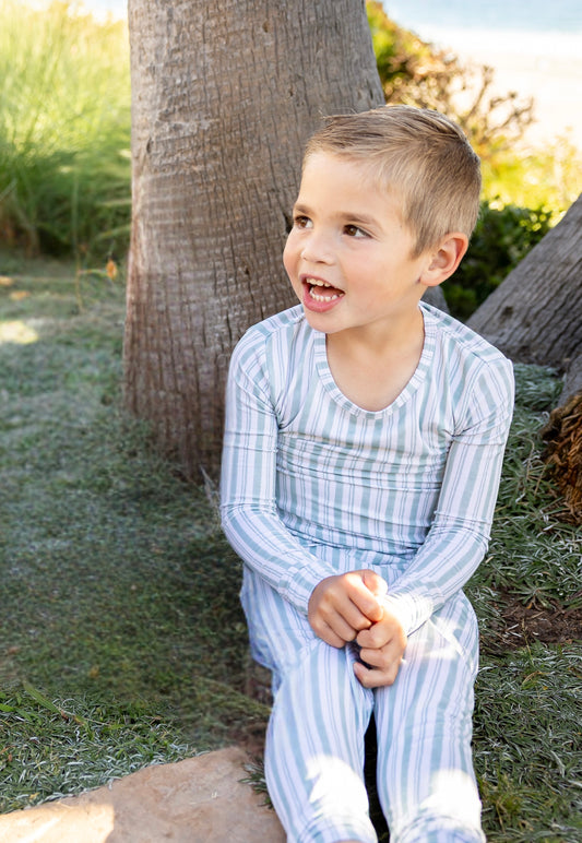 Toddler wearing Shae & Palmer Studio Stripe Green Haze bamboo pajamas featuring modern muted green stripes and buttery-soft breathable bamboo fabric.