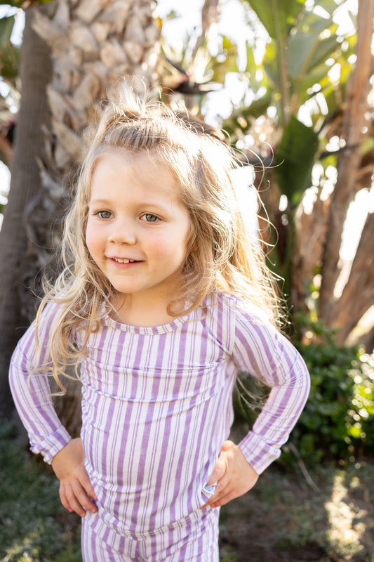 Toddler wearing Shae & Palmer Studio Stripe Purple Haze bamboo pajamas featuring muted purple painterly stripes, ultra-soft breathable bamboo fabric, and a cozy two-piece design for sleep and play.