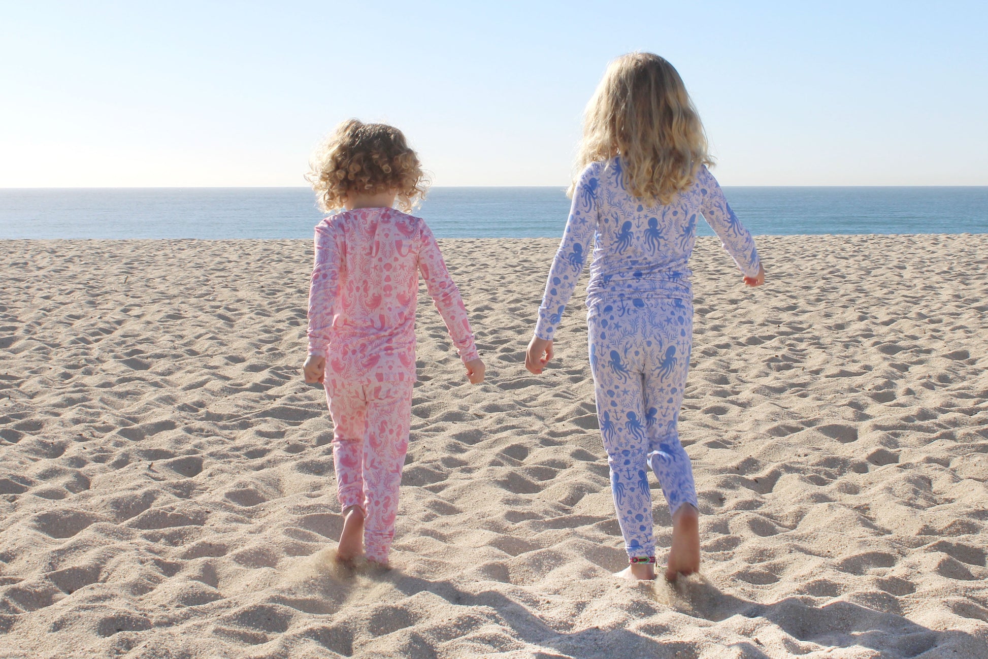 Toddler girl wearing Shae & Palmer Mermaid Cove bamboo pajama set with soft pink mermaid and seashell print.