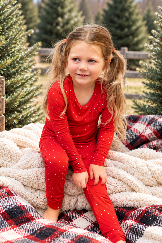 Toddler wearing Ruby Dot red bamboo pajamas with a delicate white polka dot print, soft cozy Christmas holiday sleepwear for toddlers