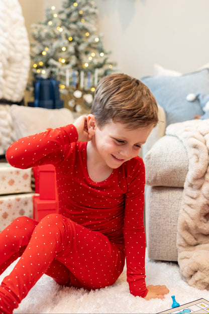 Kids wearing Ruby Dot bamboo pajamas by Shae & Palmer featuring a festive red polka dot print. Soft, breathable Christmas pajamas perfect for matching family holiday photos and cozy Christmas mornings.